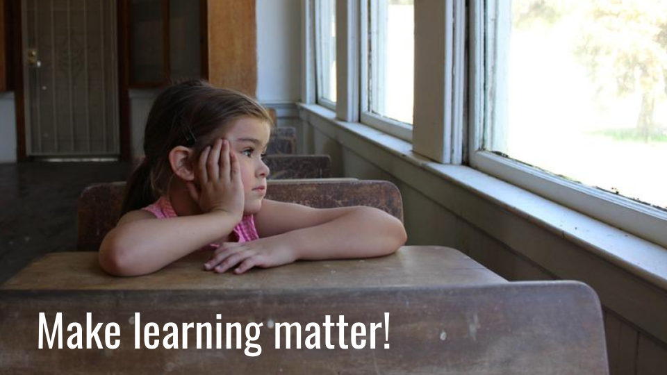 image of bored child at a desk looking out the window